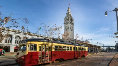 Red and yellow vintage streetcar in front of San Francisco Ferry Building.