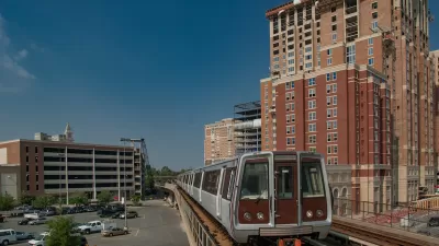 WMATA train on elevated track passing by brick multistory buildings in Alexandria, Virginia.