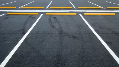 Empty asphalt parking lot with white lines.