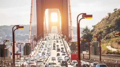 View of traffic on Golden Gate Bridge at sunset.