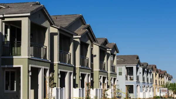 Row of newly constructed green two-story townhomes.