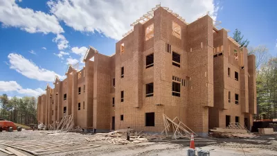 Wood-framed four-story building under construction.