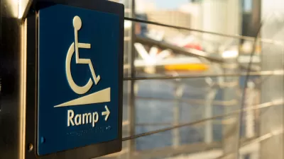 Close-up of blue and white wheelchair ramp sign with arrow pointing right.