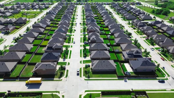 Single-family homes with green lawns in suburban Princeton, Texas.