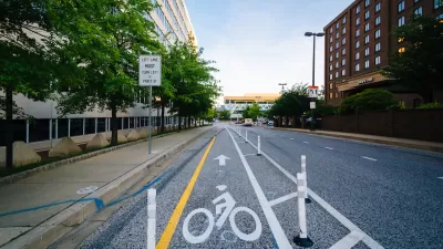 Bike lane protected by plastic delineators on street in downtown Baltimore, Maryland.