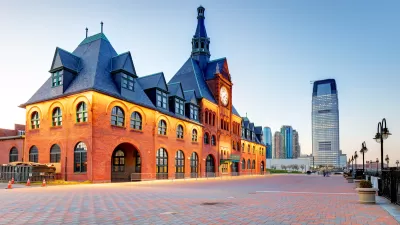 Red brick historic Central Railroad of New Jersey Terminal, Liberty State Park, New Jersey with glass high-rise building in background.