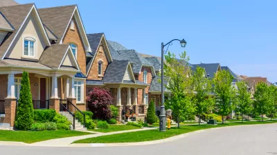 Row of single-family houses on suburban street on sunny day.