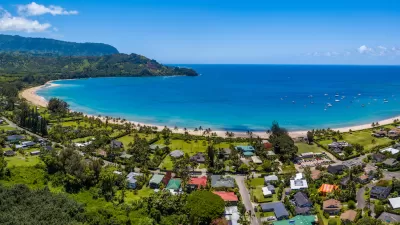 Aerial view of coastal development and bright blue ocean in Kaua'i, Hawai'i.