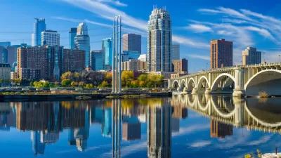 Minneapolis, Minnesota skyline with river and bridge in foreground.
