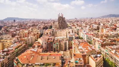 Aerial view of Barcelona, Spain with Sagrada Familia church in middle among dense buildings.
