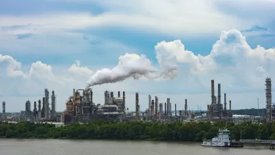 Cheical plant with shite steam coming out of metal towers on riverbank in Louisiana.