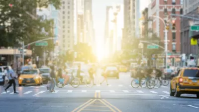 Busy crosswalk with people and bikes in New York City on a bright afternoon.