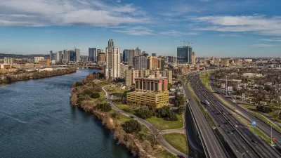 Austin skyline at dusk with a river on the left and I-35 running along the right.