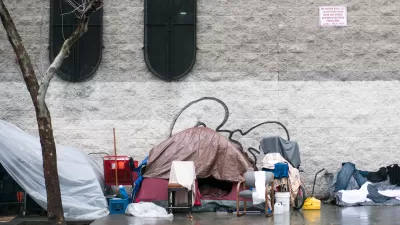 Tent covered with tarp with bike and other objects on sidewalk in Skid Row, downtown Los Angeles