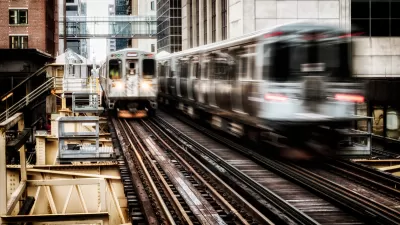 View of two blurred Chicago el trains passing on elevated track between buildings