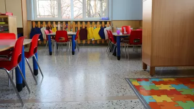Empty kindergarten classroom with colorful chairs and floor mats.