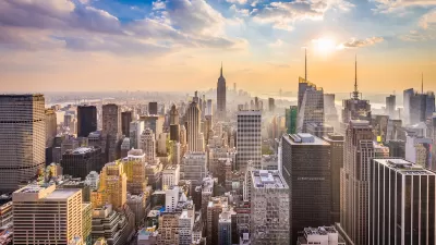 New York City skyline with Empire State Building in center and blue cloudy sky.
