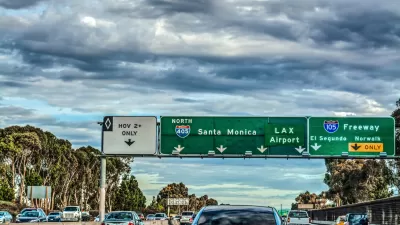 Traffic and green freeway signs with Santa Monica and LAX destinations on Interstate 405 in Los Angeles, California