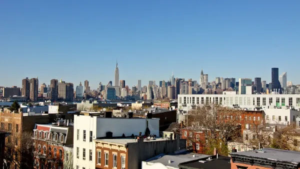 Manhattan skyline seen from Brooklyn, New York City with brick apartment buildings in foreground.