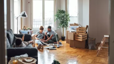 Man, woman, and child in apartment with moving boxes and crates.