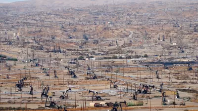 View of vast oil drilling field with black oil derricks near Bakersfield, California