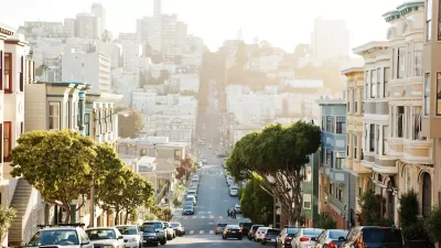 View down San Francisco street downhill with cars parked on both sides.