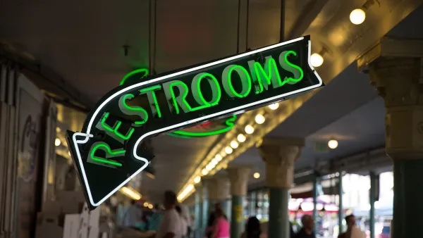 Close-up of green neon Restrooms sign.