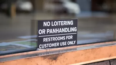 Close-up of "No Loitering or Panhandling - Restrooms for Customer Use Only" sign in shop window.