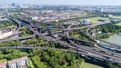 Aerial view of five-level freeway interchange in Houston, Texas with bridges spanning green bayou.