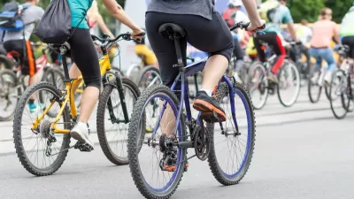Large group of cyclists on city street.