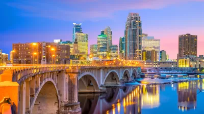 Late evening view of downtown Minneapolis skyline with stone bridge in foreground