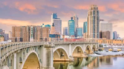 Downtown Minneapolis, Minnesota skylinw with stone arched brige in foreground.