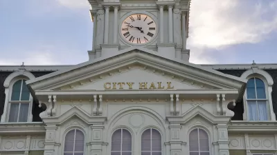 White neoclassical building with cupola and City Hall lettering on front.