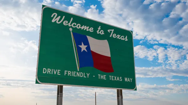 Green road sign with "Welcome to Texas" above Texas flag and "Drive Friendly - the Texas Way" below. 