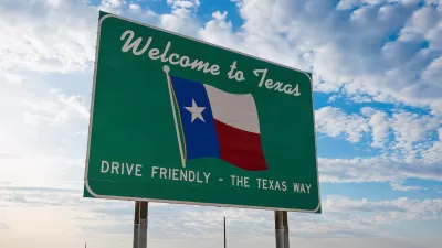 Green road sign with "Welcome to Texas" above Texas flag and "Drive Friendly - the Texas Way" below.