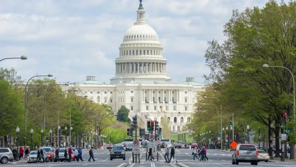 People crossing the street in a crosswalk with U.S. capitol dome visible in background on Pennsylvania Avenue in Washington DC.