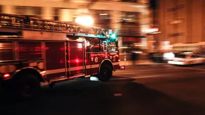 Chicago fire department fire truck driving down street with blurred background indicating motion at nighttime.