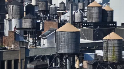 Old water towers on dense New York City rooftops.