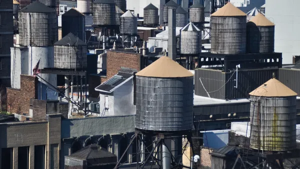 Old water towers on dense New York City rooftops.