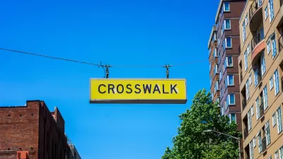 Yellow CROSSWALK sign hanging above a street in downtown Seattle, Washington.