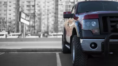 Low close-up of front of large parked pick-up truck.