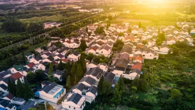 Aerial view of single-family homes in Houston suburb with setting sun in background