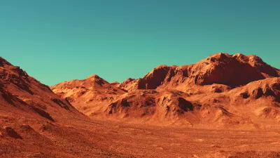 Barren rocky landscape against teal sky.