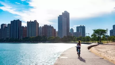 Cyclist riding along paved path at edge of Lake Michigan in Chicago, Illinois.