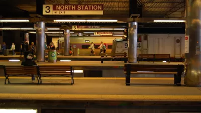 Few passengers waiting in subway station with multiple platforms and "North Station" signs in Boston, Massachusetts