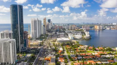 Aerial view of Miami, Florida with high-rises along beach and low-rise homes inlower right corner