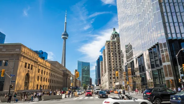 Busy street in Toronto, Canada with CN Tower visible in background.