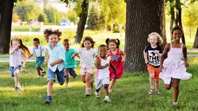 Group of children running toward the camera on a green lawn
