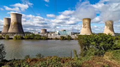 View of Three Mile Island nuclear power plant with four reactor towers on a sunny day.