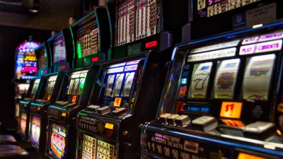 Close-up of row of slot machines in dark casino.